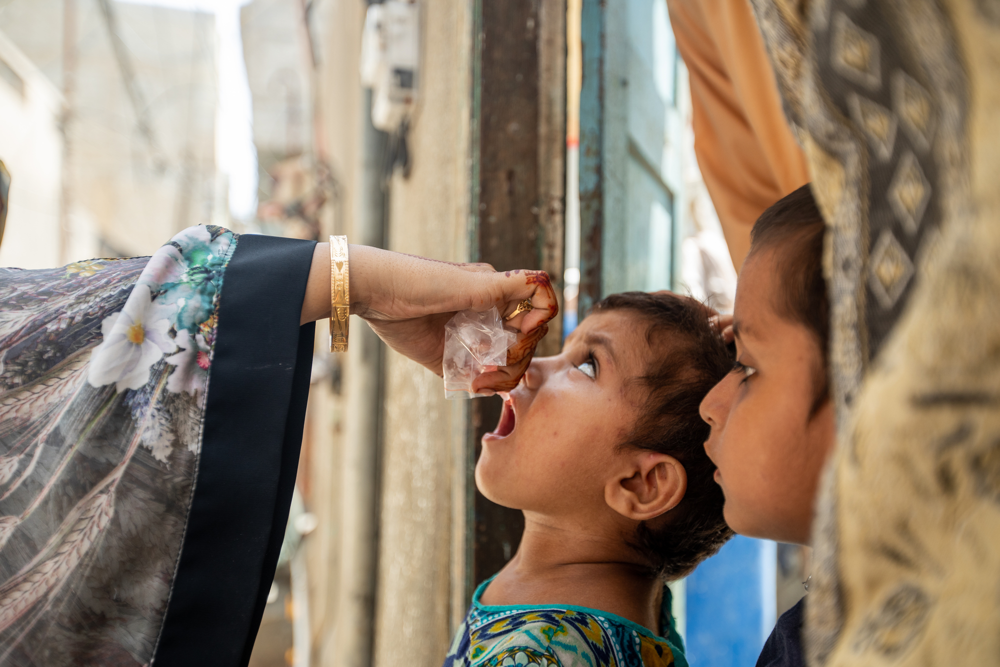 Soniya (2.5), is immunized by polio vaccinator Qurat-ul-Ain (28) in Hijrat Colony, Lyari, Karachi, Pakistan on September 22, 2020.  