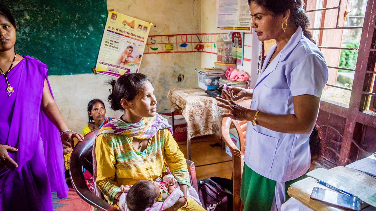 Gayatri Ahirwar, Auxiliary Nurse Midwife (ANM), explains the immunization process to Savitri, for her son, Paras, at an Anganwadi Centre (AWC) in Bhopal, Madhya Pradesh, India on September 26, 2018.