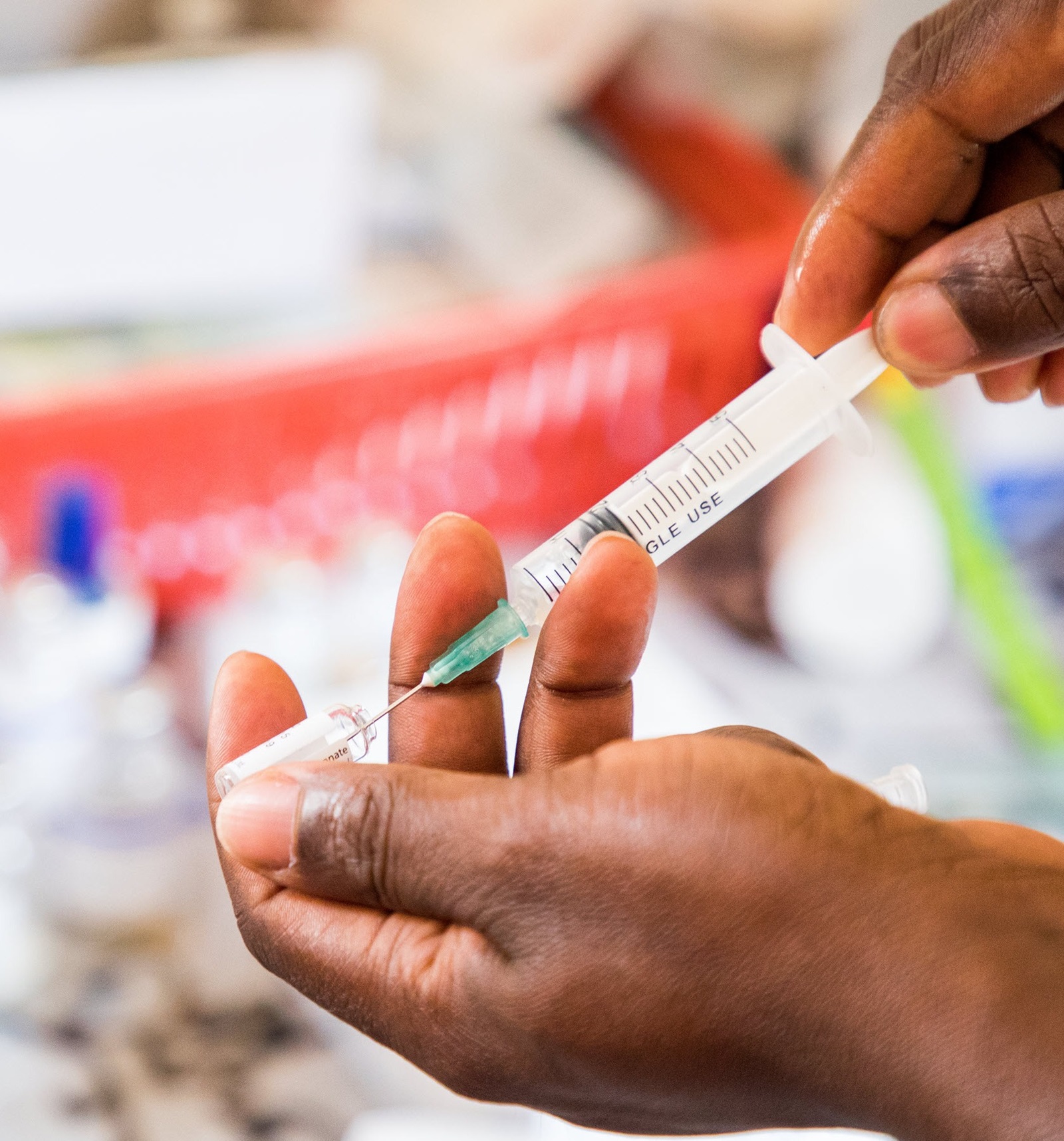 A health care worker prepares a malaria medication at a health center in Zambia.