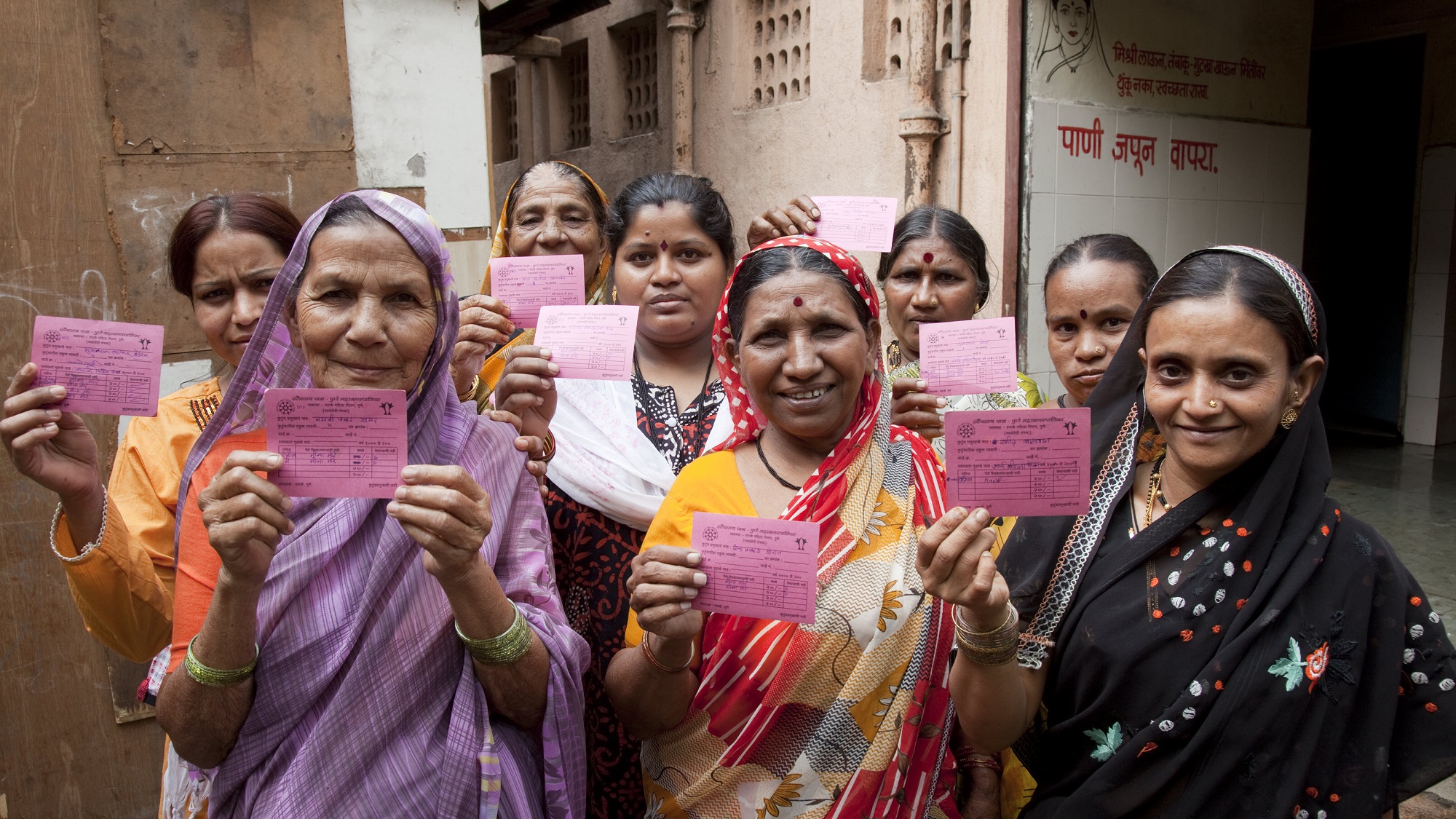 Users with membership cards at a community toilet for women in an urban slum in Pune, India.