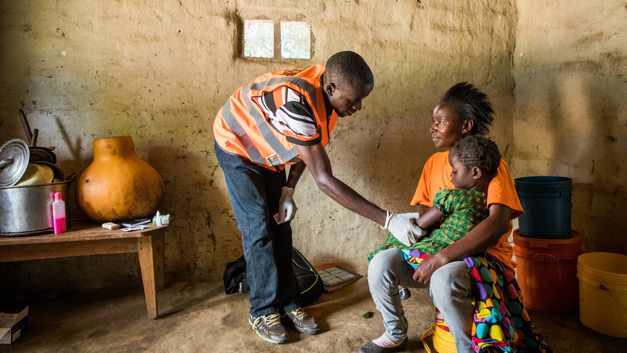 A community health volunteer visits a child who has malaria in Zambia. 