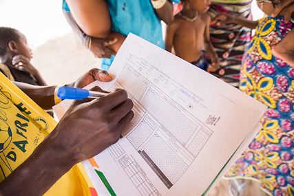 Polio vaccinator marks down children that have been vaccinated