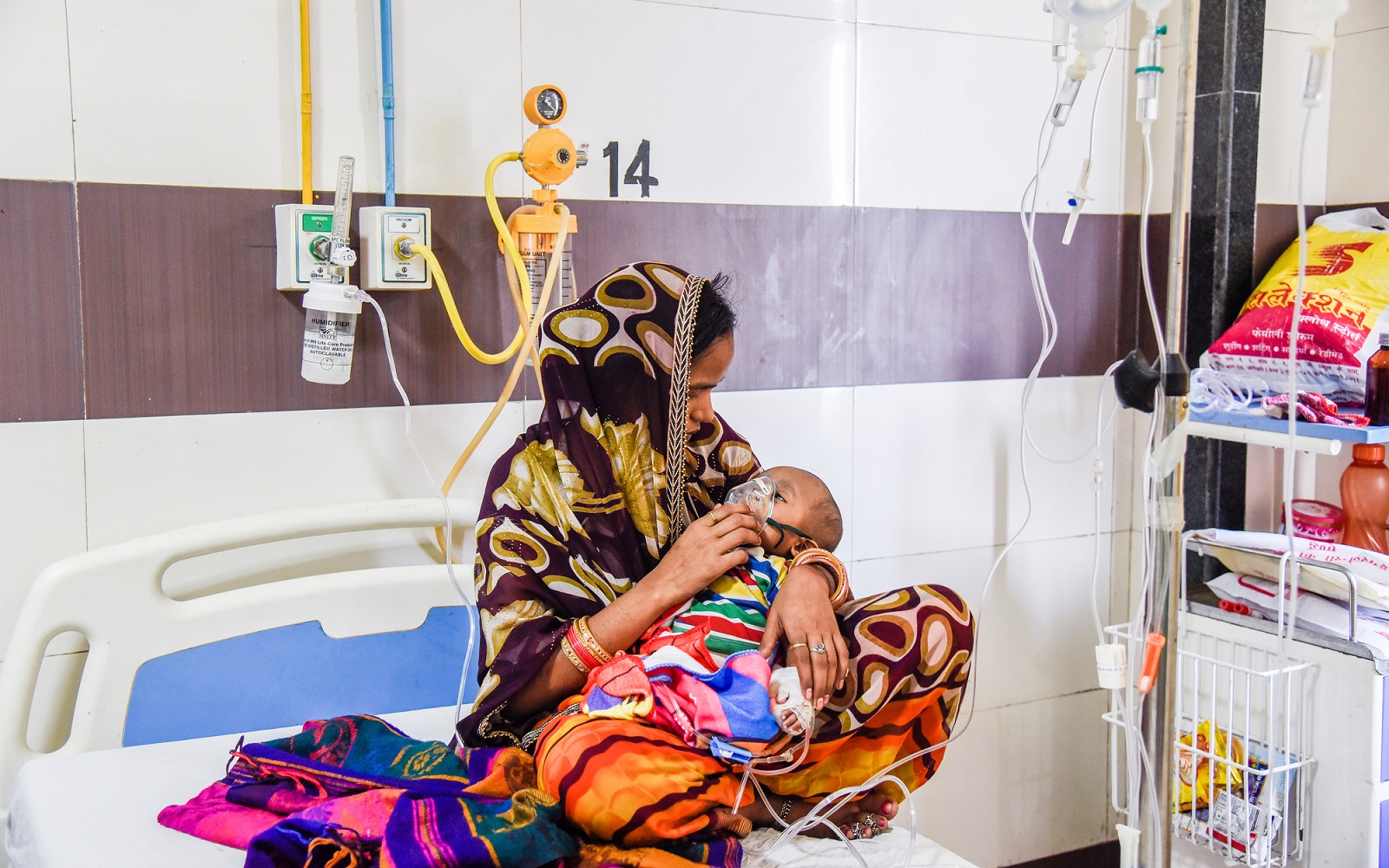 A 7-month-old suffering from pneumonia is taken care of by his mother in the pediatric ward at King George's Medical University, Lucknow, India, September 19, 2018.