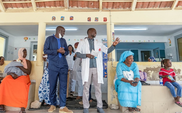 Aboubacar Diop (center right) speaks to parents about the importance of HPV vaccinations at a clinic in Saint Louis, Senegal. 