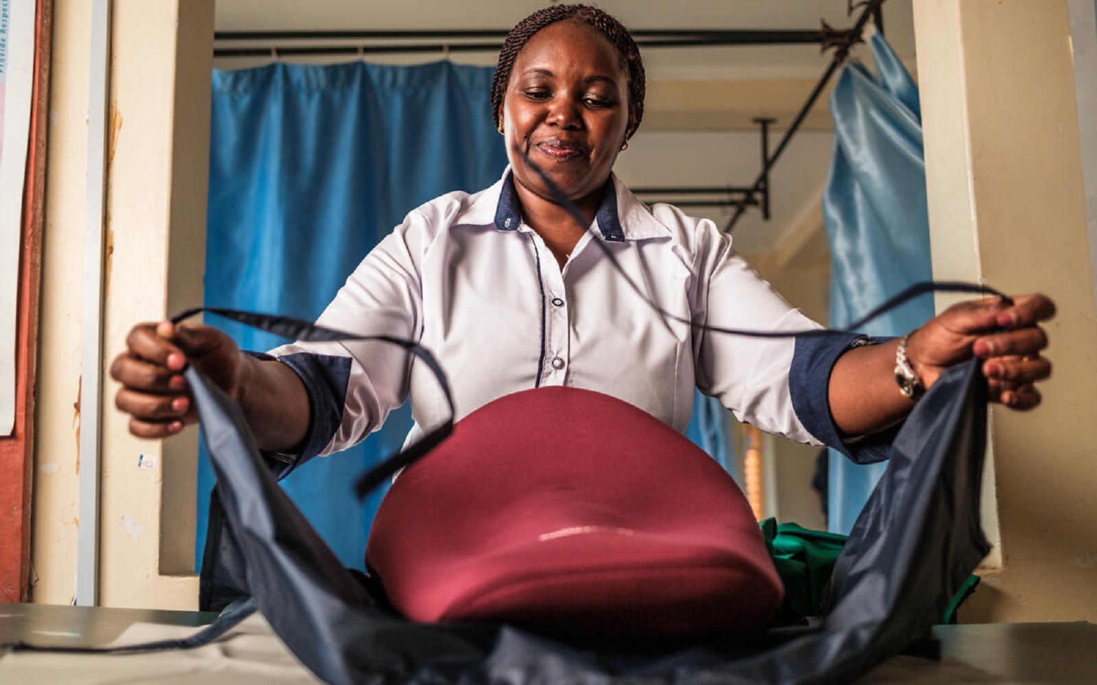 A nurse manager, demonstrates how to use a drape to prevent postpartum hemorrhage (PPH) at Makueni County Referral Hospital in Makueni County, Wote, Kenya.