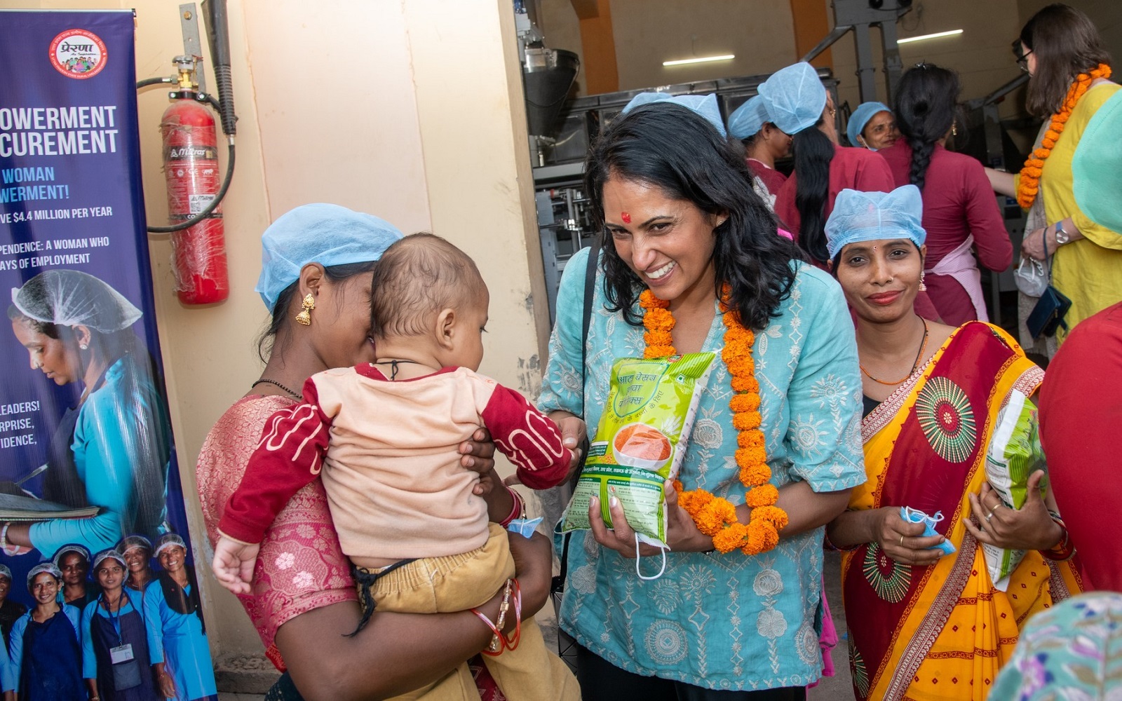 Gargee Ghosh, President, Global Policy & Advocacy, speaks with female workers during a visit to the 'Take Home Ration' (THR) Plant in Uttar Pradesh, India.