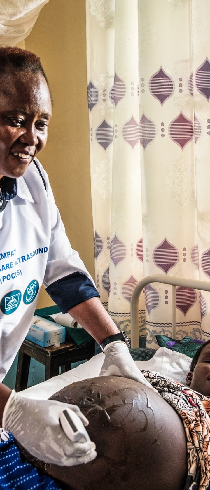 Christine Watima, Nurse at Nasusi Health Centre in Kimilili Sub-County, performs an ultrasound scan on an expectant mother using a point-of-care ultrasound (POCUS) machine at Nasusi Health Centre. 