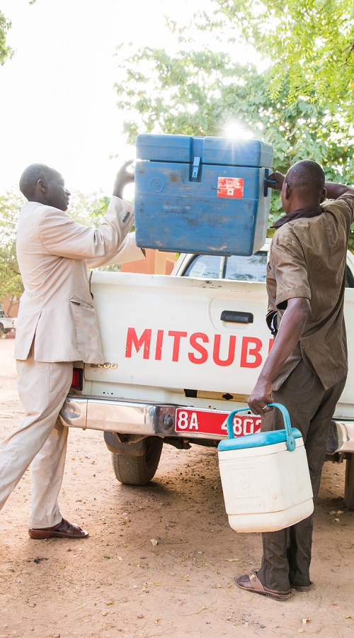 Marou Haïnikoye (left) and Hamidou Hamadou (center) carry a cold box used to transport vaccines at the Dosso Health Centre. The vaccines are distributed to nearby communities in the Dosso region of Niger. 