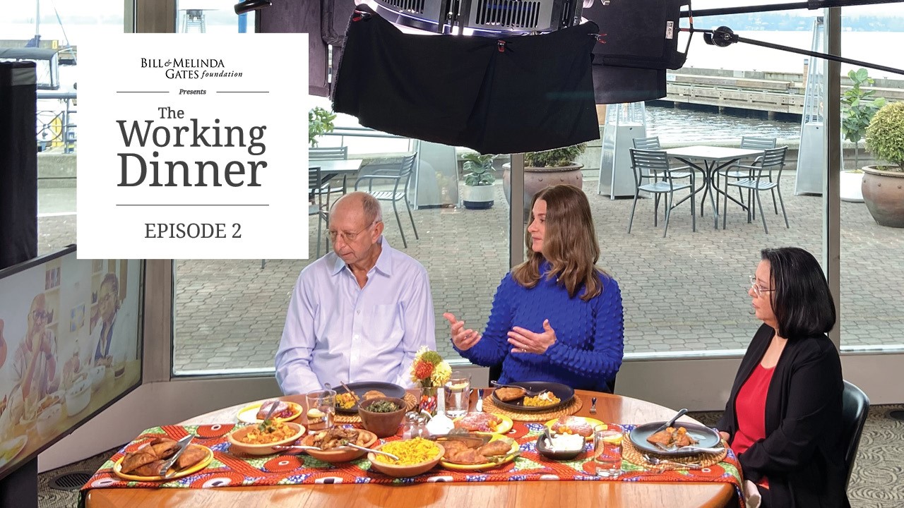 Keith Klugman, Melinda French Gates, and Anita Zaidi meet over dinner with guests Catherine Nyambura and Dr. Githinji Gitahi joining virtually on a television monitor