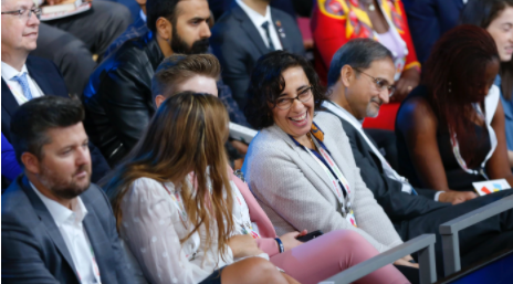 A group of people sit and listen to Goalkeepers speakers