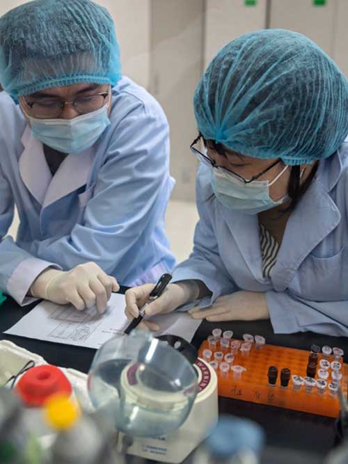 Рабочие разрабатывают наборы реагентов для COVID-19 в научно-исследовательской лаборатории Beijing Applied Biological Technologies (XABT) в Китае. (Фото любезно предоставлено Николасом Асфури / AFP через Getty Images 14 мая 2020 г.)