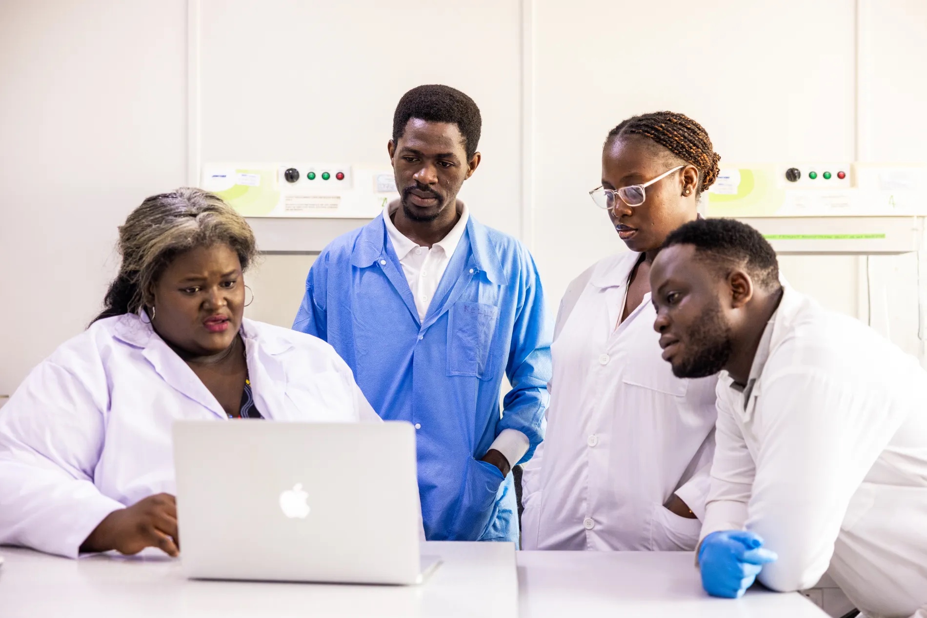 Krystal Mwesiga Birungi, an entomologist with Target Malaria Uganda, reviews research data on malaria-transmitting mosquitoes with laboratory technologists at the Uganda Virus Research Institute in Entebbe, Uganda.