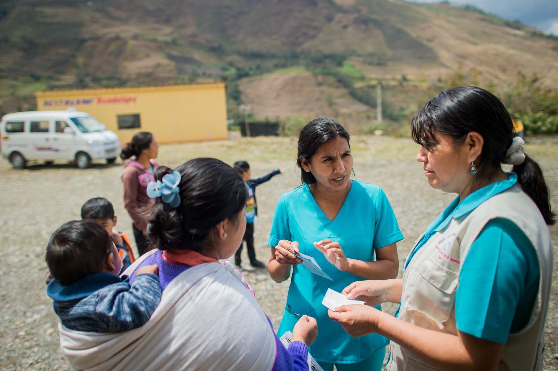 Picture of nurses from a local health program counsel a mother on how best to care for her young children. (Acomayo, Peru)